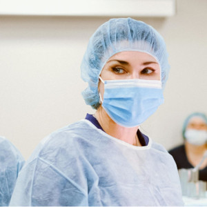 Chirurgische Schutzkleidung Eine Ärztin in chirurgischer Schutzkleidung